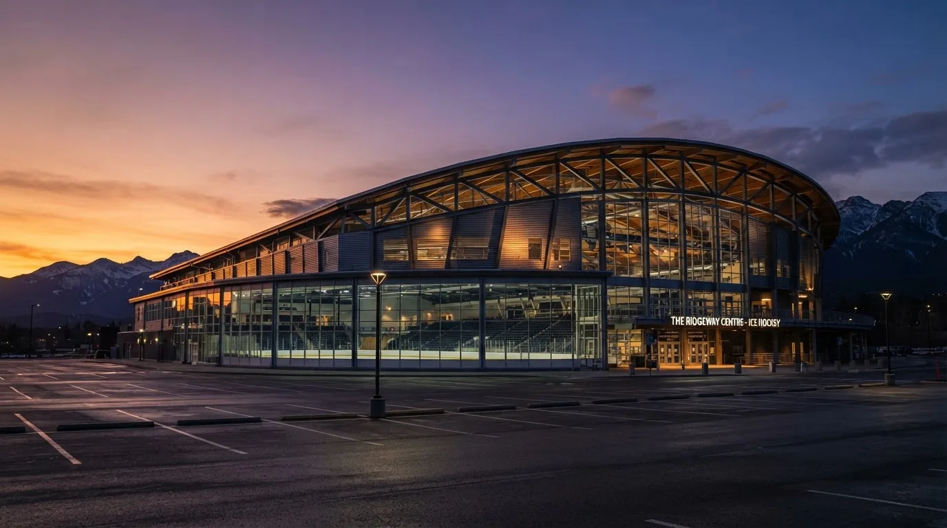 Un estadio de fútbol vacío con torres de iluminación al atardecer