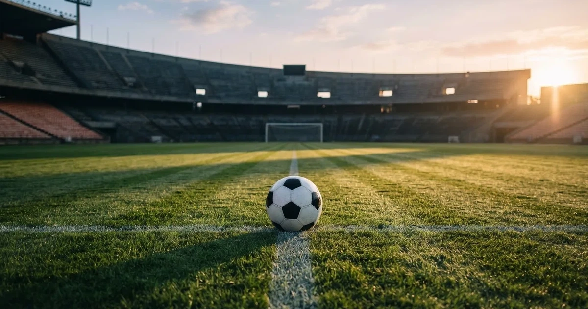 Un balón en el punto central de un campo de césped a la luz de la mañana