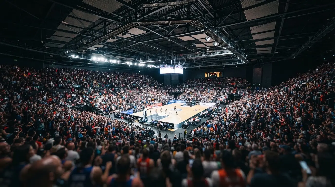 Un pabellón deportivo lleno bajo los focos, fotografiado desde muy lejos