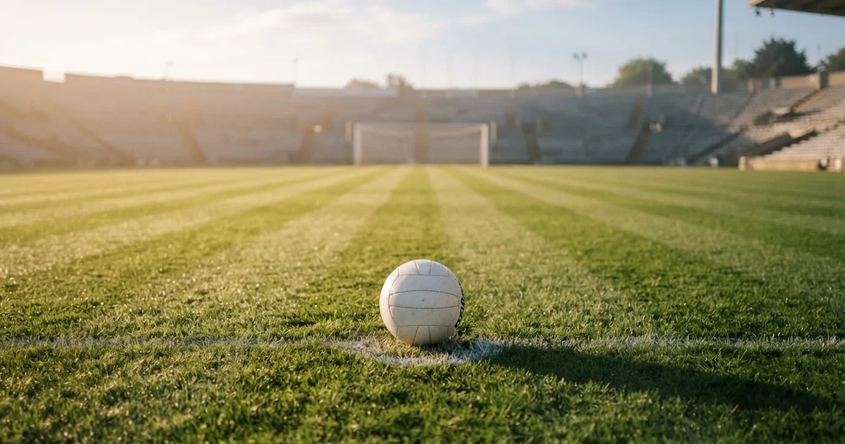 Un balón en el punto central de un campo de césped a la luz de la mañana